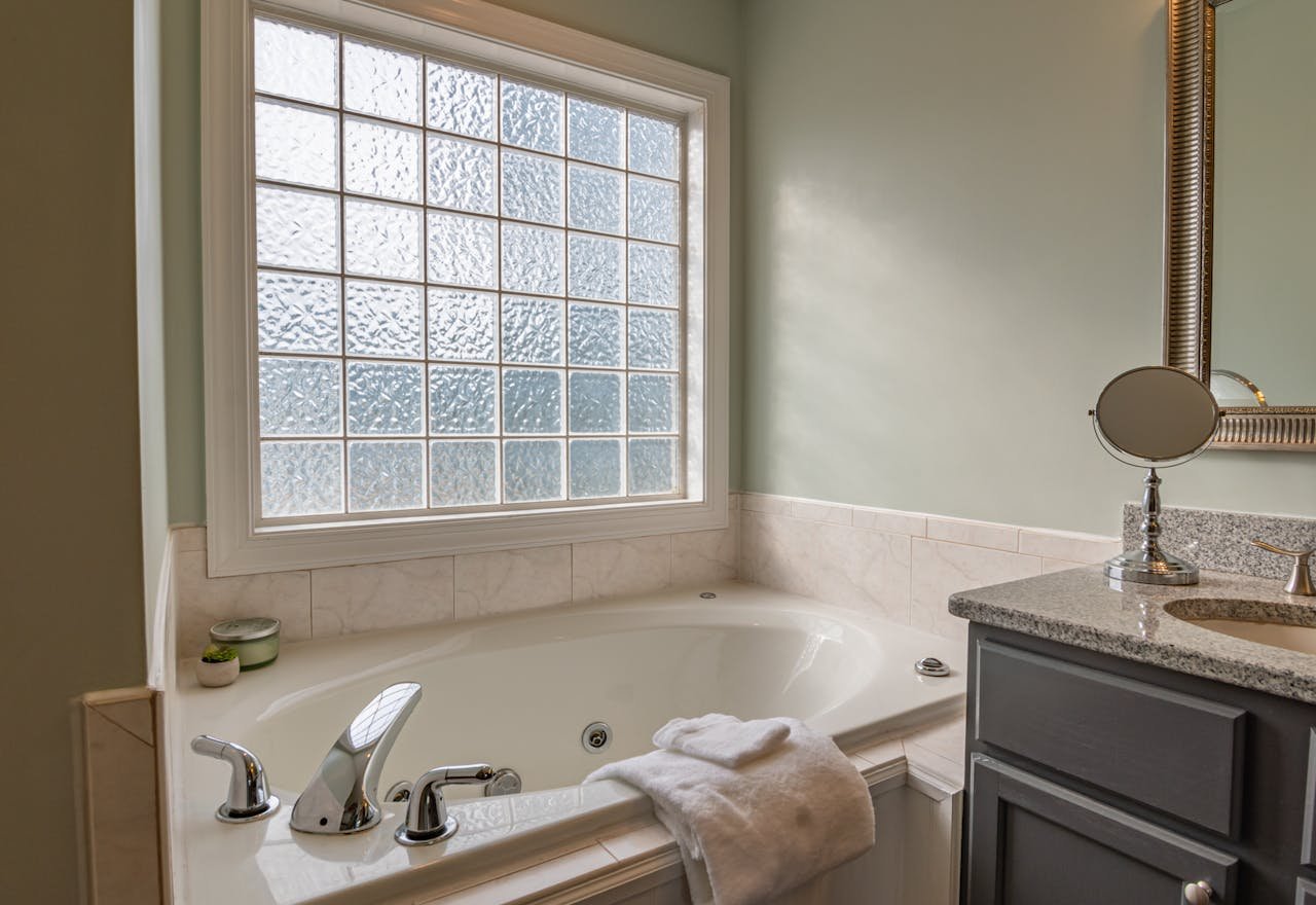 Offerings Stylish modern bathroom featuring a luxury bathtub, sleek sink, and large window. Perfect for relaxation.